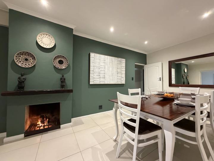 Dining room with a fireplace and a green feature wall
