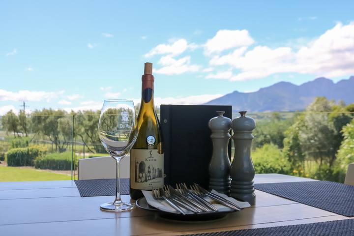 A table with wine and a glass and the mountains behind