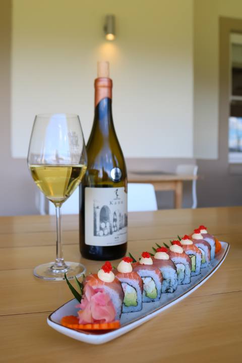 Sushi and a glass of wine on a wooden table