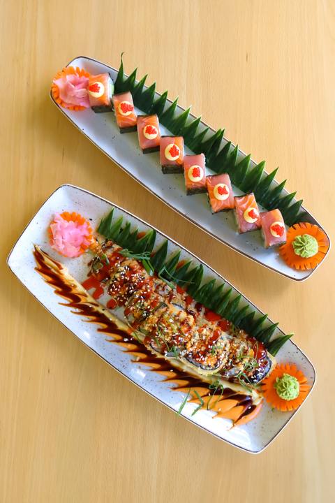 Two sushi platters on a wooden table