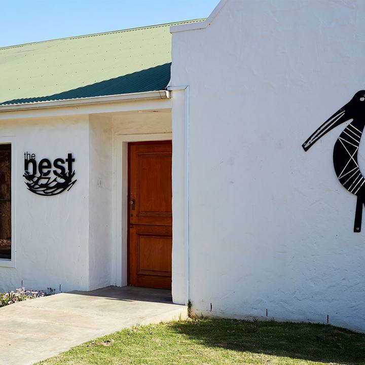 Whitewashed farm building with a carved bird on the wall