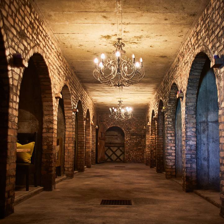 Chandelier-lit brick corridor in the underground cellar
