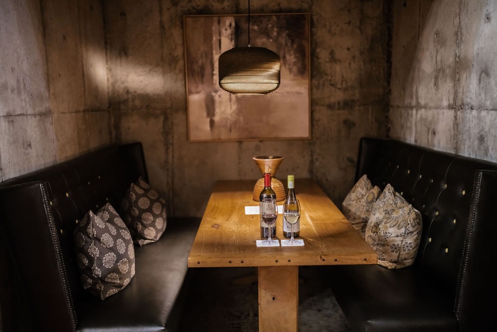 A private tasting booth in the underground cellar, with Kanu wines on a wooden table
